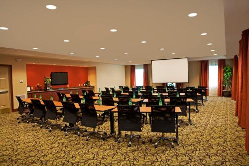 a conference room with tables and chairs and a white screen at Staybridge Suites Chantilly Dulles Airport by IHG in Chantilly