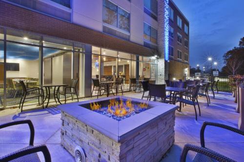an outdoor patio with a fire pit and tables and chairs at Holiday Inn Express & Suites Grand Rapids Airport North by IHG in Grand Rapids
