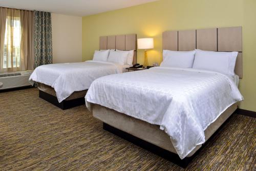 a hotel room with two beds with white sheets at Candlewood Suites - Lodi by IHG in Lodi