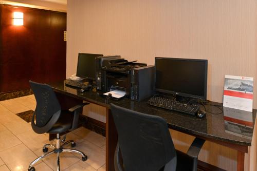 an office with three computer monitors on a desk at Holiday Inn Express Edmonton North by IHG in Edmonton