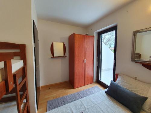 sypialnia z łóżkiem piętrowym i przesuwnymi szklanymi drzwiami w obiekcie Green Garden Gajac Apartman w mieście Skunca