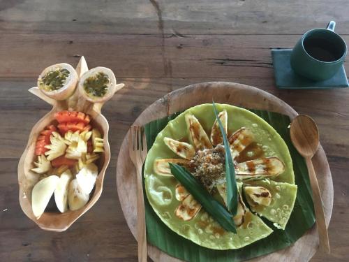 un plato de comida con camarones y verduras en una mesa en Green Vanilla Bungalow en Sidemen