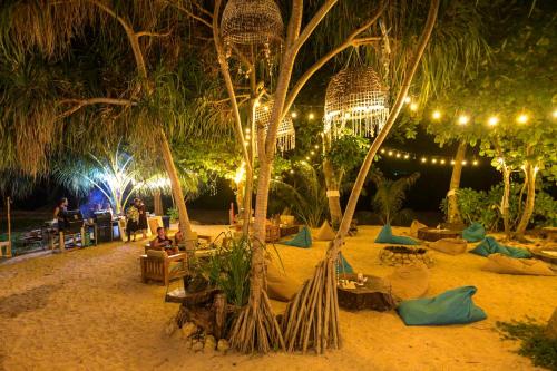 a beach with palm trees and lights at night at By The Sea Koh Mak Boutique Guesthouse in Ko Mak