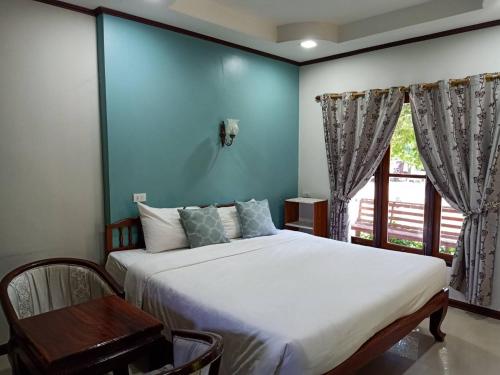a bedroom with a large bed and a window at Saithong Resort in Udon Thani