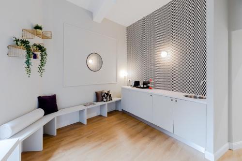 Habitación blanca con banco y mesa en Suites by Chloe, en Roma