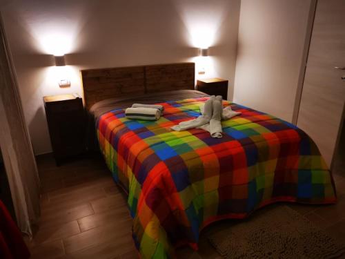 a bed with a stuffed animal on a colorful blanket at B&B Belli Dentro in Verona
