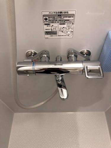 a chrome toilet paper dispenser on a ceiling at THE MICKEY CARLTON Ohashi 201 in Shiobaru
