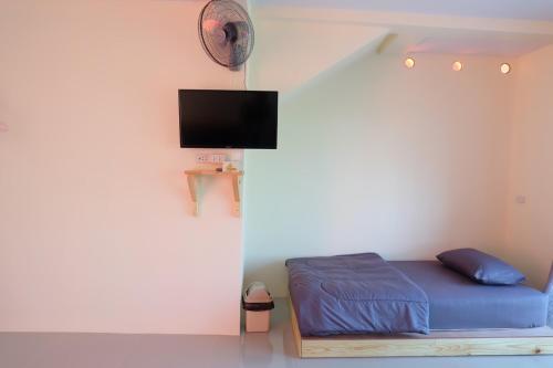 a bedroom with a bed and a flat screen tv at เอนกาย อิงเขา (Anguyingkhao) in Khao Kho