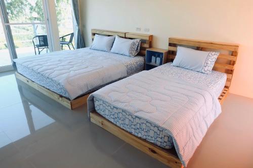 two beds sitting next to each other in a bedroom at เอนกาย อิงเขา (Anguyingkhao) in Khao Kho