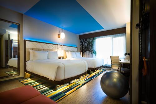 紐約的住宿－EVEN Hotel New York - Times Square South, an IHG Hotel，一间卧室设有两张床和蓝色的天花板