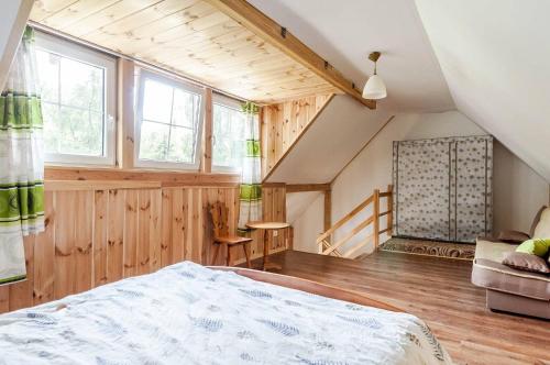 an attic bedroom with a bed and a staircase at Agroturystyka Leśna Dolinka in Narty