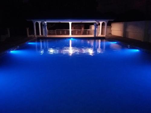 a swimming pool lit up at night with blue lights at Aikaterinis in San Narciso
