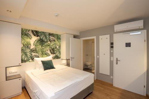 a bedroom with a large bed with a painting on the wall at Wilmas Apartments by Arbio in Vienna