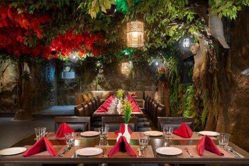 a dining room with a table with red napkins at Cygnett Style Tania's in Siliguri