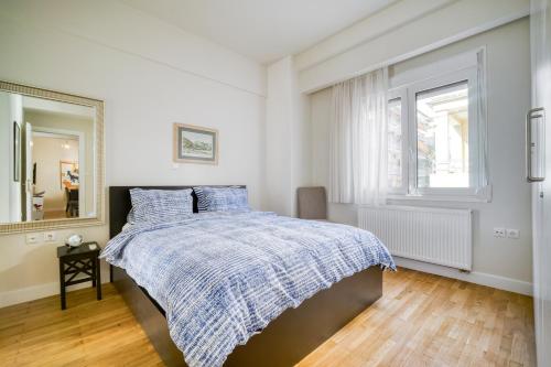 a white bedroom with a bed with a blue blanket at Lovely Sunlit Central Athens 2 Bedroom 2 Bathroom Condo in Athens