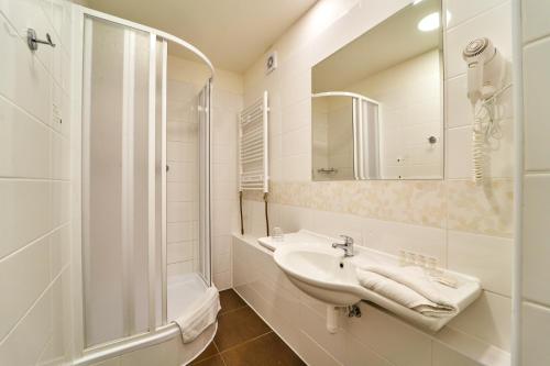 a bathroom with a shower, sink, and tub at Charles Central in Prague