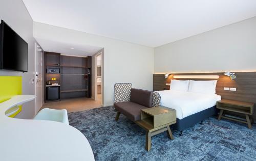 a hotel room with a bed and a chair at Holiday Inn Express Brisbane Central by IHG in Brisbane