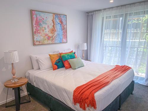 a bedroom with a large bed with colorful pillows at MyHolidays - The Four Seasons Queenstown in Queenstown