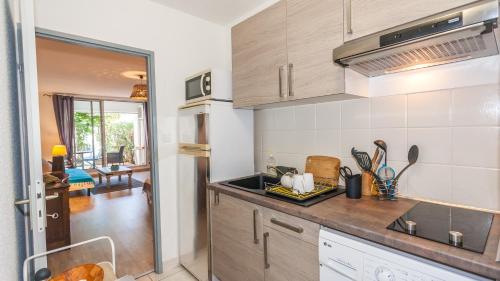 a kitchen with a sink and a counter top at Grand T1 avec terrasse à 5min des plages et 400m de St Gilles Les Bains in Saint-Gilles les Bains