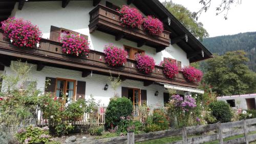 une maison avec des fleurs sur ses balcons dans l'établissement Pension Mühlbauer, à Bayrischzell