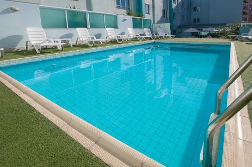 伊塔佩馬的住宿－伊塔佩馬索利斯海灘酒店，一座带椅子的大型蓝色游泳池
