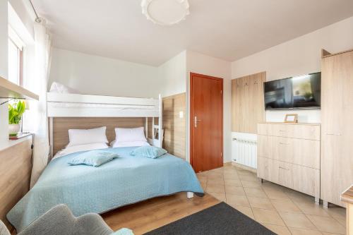 a bedroom with a bed and a tv on the wall at Szymonówka W Szklarskiej Porębie in Szklarska Poręba