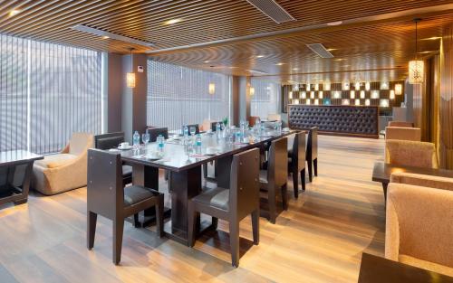 a long dining room with a long table and chairs at Cygnett Style Tania's in Siliguri