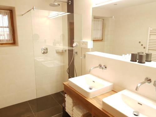 een witte badkamer met een wastafel en een douche bij Ferienwohnungen Christine in Waidring