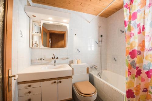 フルティゲンにあるChalet Bergweltのバスルーム(洗面台、トイレ、バスタブ付)
