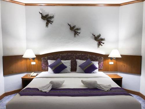 a bedroom with a large bed and two lamps at Krabi Golden Hill Hotel in Krabi town