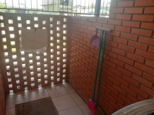 a room with a brick wall with a mop at Pousada ACM Tramandaí - RS in Tramandaí