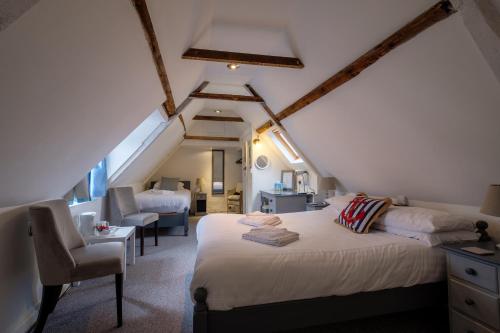 a bedroom with a bed and a chair in a attic at Newport Quay in Newport