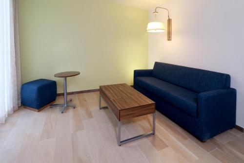 a living room with a blue couch and a table at Holiday Inn Express & Suites - Playa del Carmen by IHG in Playa del Carmen