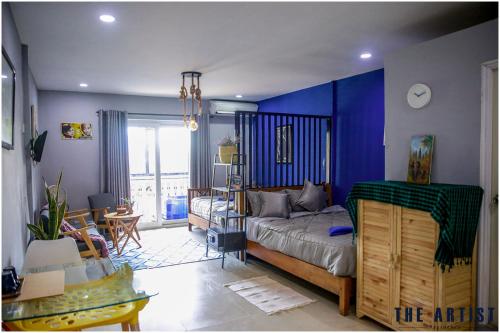 a bedroom with a bed and a blue wall at The Artist Residence in Phnom Penh