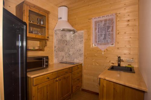 eine Küche mit einer Spüle und einem Kühlschrank in der Unterkunft Chalet Obertraun in Obertraun