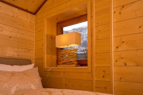 ein Schlafzimmer mit einem Fenster in einem Blockhaus in der Unterkunft Chalet Obertraun in Obertraun