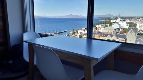 a table and two chairs in front of a window at El encanto del lago in San Carlos de Bariloche