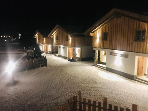 a person riding a bike down a snow covered street at night at Sieglhub Chalets - Appartements - Hotel in Flachau