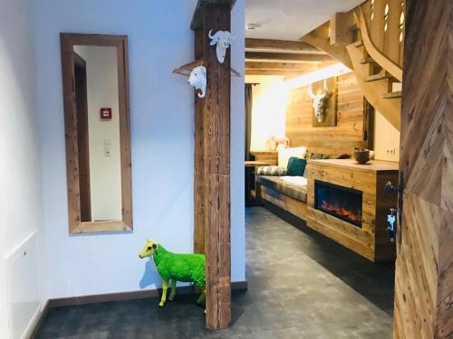 a living room with a fireplace and a green sheep statue at Sieglhub Chalets - Appartements - Hotel in Flachau