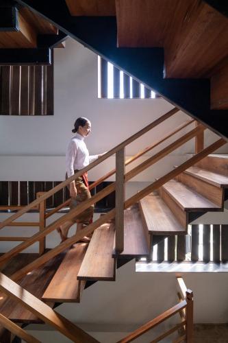 a woman walking down a wooden stairs at Hotel Gahn Khao Lak in Khao Lak