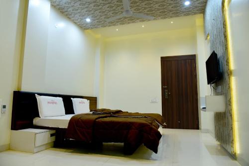 a bedroom with a bed and a television in it at Hotel Pushpak in Satara