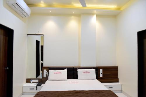 a bedroom with a large bed and a mirror at Hotel Pushpak in Satara