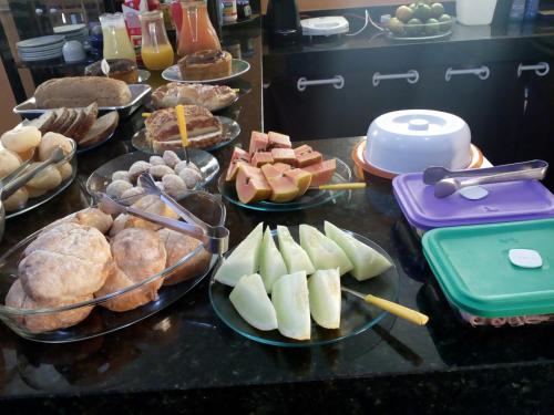 a table with plates of food and pastries and pies at Pousada Quatro Estações in Alto Paraíso de Goiás