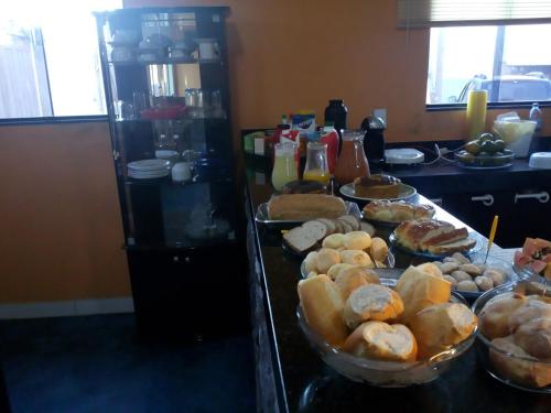 a buffet with many different types of bread and pastries at Pousada Quatro Estações in Alto Paraíso de Goiás