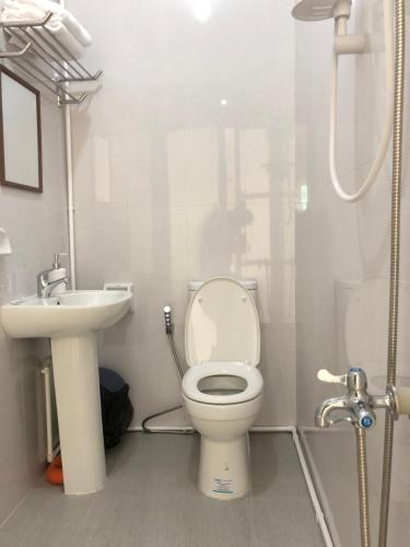 a bathroom with a toilet and a sink at Arriyus Apartelle in Maya