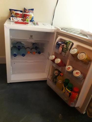 an open refrigerator filled with lots of drinks at Pousada Quatro Estações in Alto Paraíso de Goiás