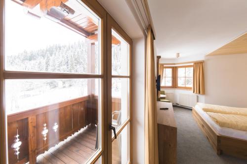 Schlafzimmer mit einem großen Fenster und einem Bett mit Aussicht in der Unterkunft Barbarahof in Werfenweng