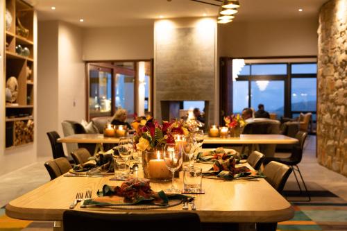 a dining room with tables with flowers and candles at Alkira Lodge in Brenton-on-Sea