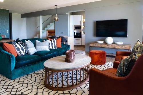 a living room with a couch and a table at Alkira Lodge in Brenton-on-Sea