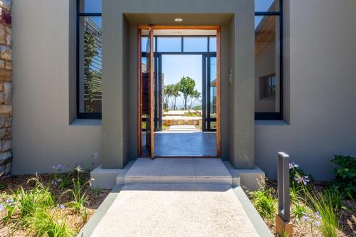 a door to a house with a view of a yard at Alkira Lodge in Brenton-on-Sea